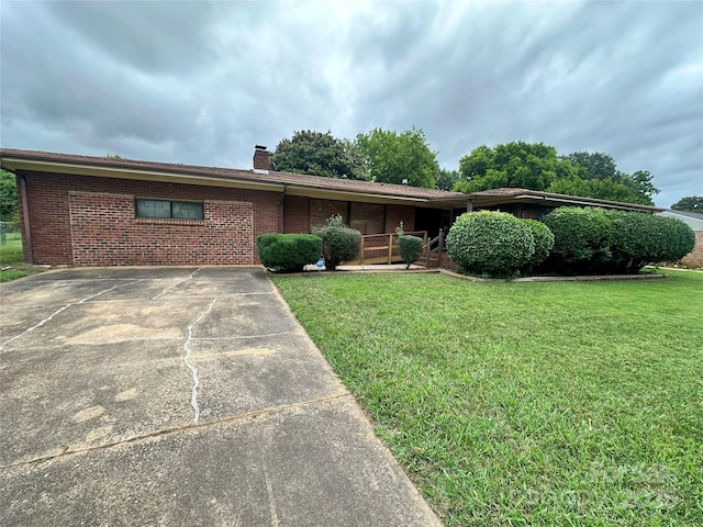 2128 Senior Dr, Charlotte, NC 28216 - view of front of home featuring a front yard, a chimney, brick siding, and driveway