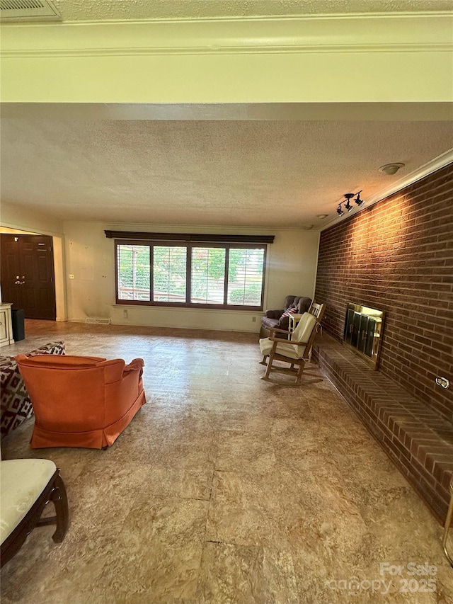 2128 Senior Dr, Charlotte, NC 28216 - living room featuring healthy amount of natural light, brick wall, and a textured ceiling