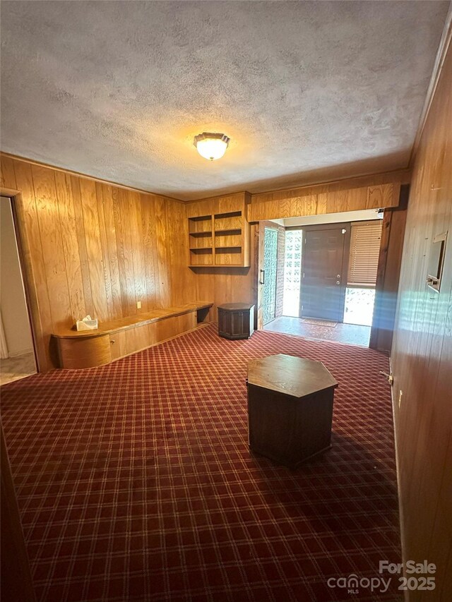 2128 Senior Dr, Charlotte, NC 28216 - miscellaneous room featuring wood walls, a textured ceiling, and carpet