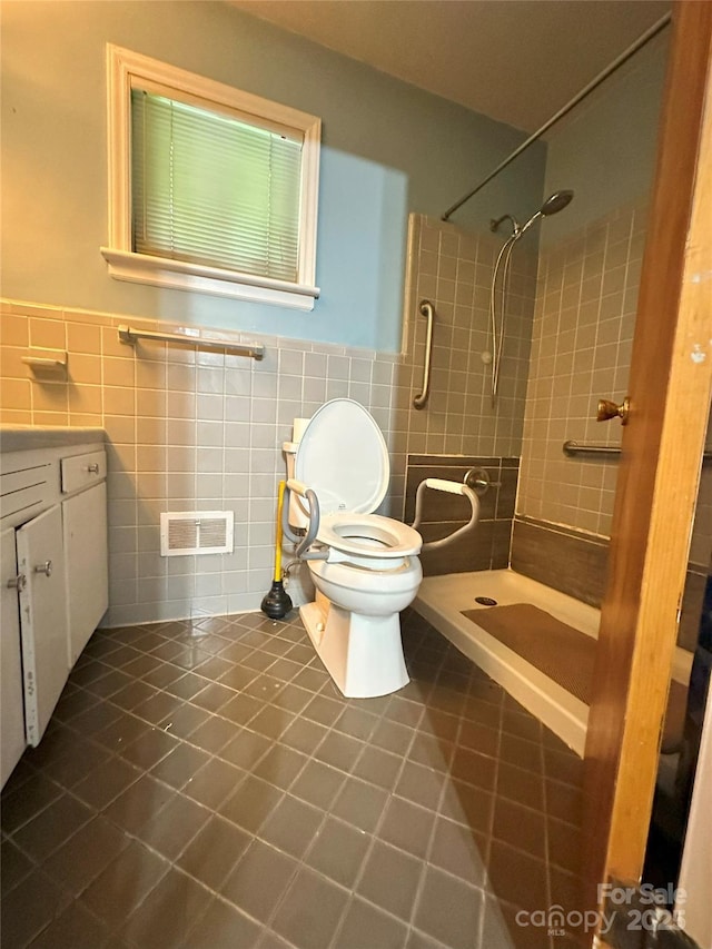 2128 Senior Dr, Charlotte, NC 28216 - bathroom featuring tile patterned flooring, tile walls, a tile shower, vanity, and wainscoting