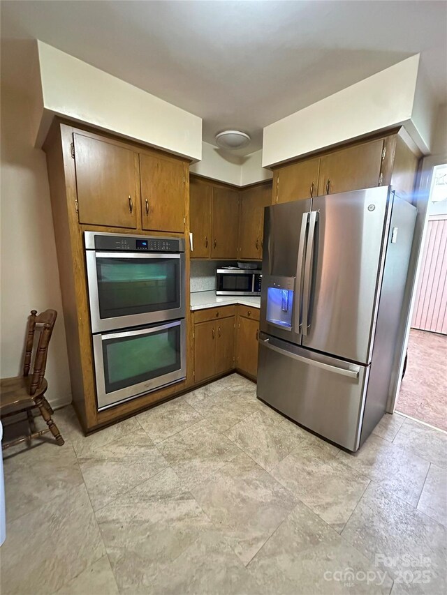 2128 Senior Dr, Charlotte, NC 28216 - kitchen with appliances with stainless steel finishes, light countertops, and light stone finish flooring