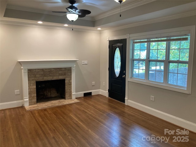 1162 Brighton Pl, Charlotte, NC 28205 - entrance foyer featuring a ceiling fan, wood finished floors, a raised ceiling, crown molding, and a brick fireplace
