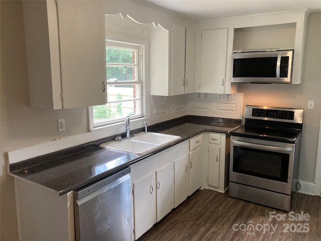 1162 Brighton Pl, Charlotte, NC 28205 - kitchen with stainless steel appliances, dark countertops, white cabinetry, and dark wood finished floors