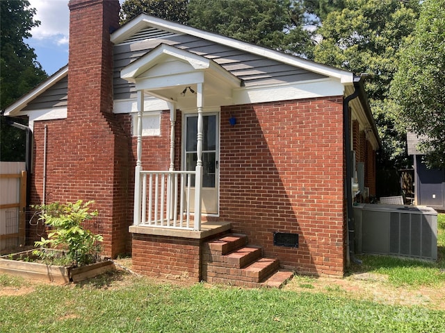 1162 Brighton Pl, Charlotte, NC 28205 - view of front of house featuring a chimney, brick siding, and a vegetable garden