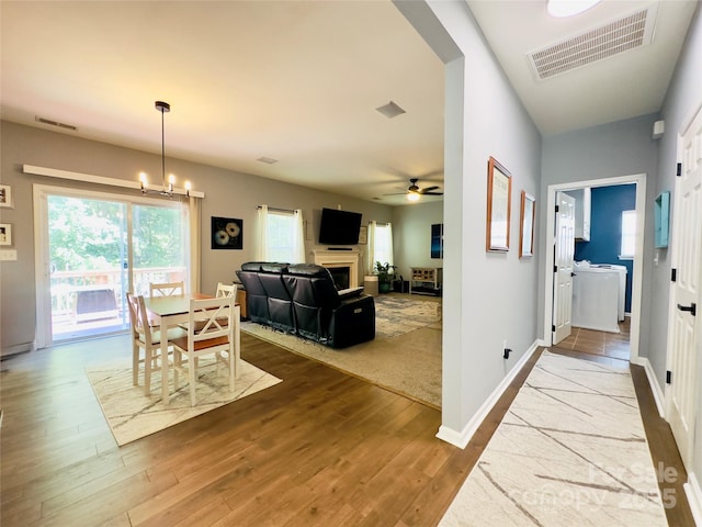 3236 Wicklow Ln, Clover, SC 29710 - dining space featuring wood finished floors, a fireplace, a ceiling fan, and a chandelier