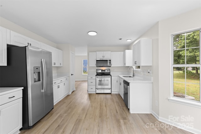6907 Spandril Ln, Charlotte, NC 28215 - kitchen with appliances with stainless steel finishes, white cabinetry, light wood-style flooring, and light countertops