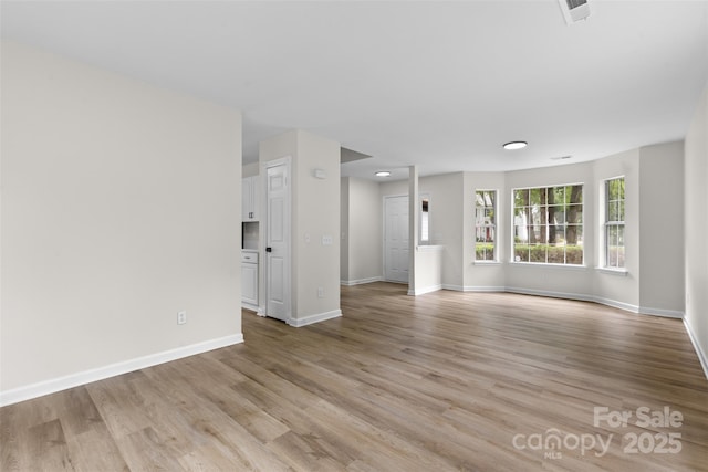 6907 Spandril Ln, Charlotte, NC 28215 - unfurnished living room with baseboards and light wood finished floors
