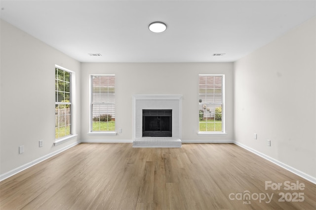 6907 Spandril Ln, Charlotte, NC 28215 - unfurnished living room featuring a fireplace and light wood-style flooring
