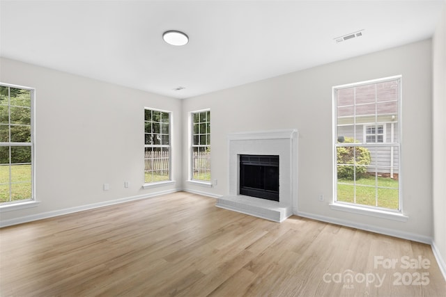 6907 Spandril Ln, Charlotte, NC 28215 - unfurnished living room with light wood-type flooring, a brick fireplace, and plenty of natural light