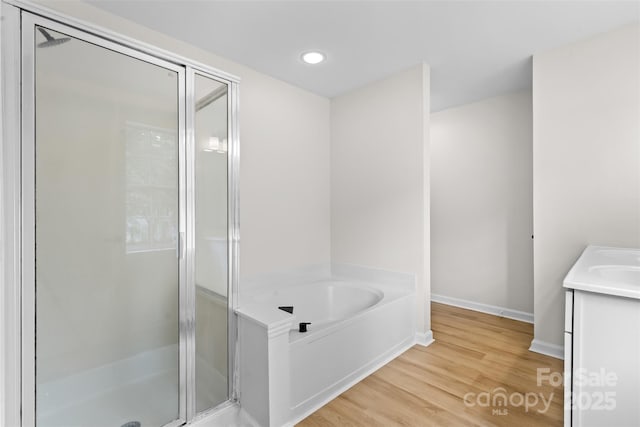 6907 Spandril Ln, Charlotte, NC 28215 - full bath with a stall shower, a bath, vanity, wood finished floors, and recessed lighting