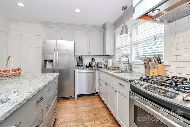 427 Lansdowne Rd, Charlotte, NC 28270 - kitchen featuring appliances with stainless steel finishes, wall chimney exhaust hood, decorative backsplash, pendant lighting, and light stone countertops