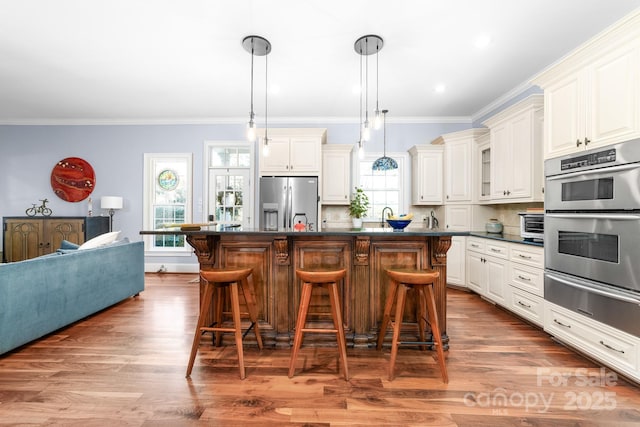 200 Galey Rdg, Cramerton, NC 28032 - kitchen featuring appliances with stainless steel finishes, a warming drawer, dark countertops, a breakfast bar area, and crown molding
