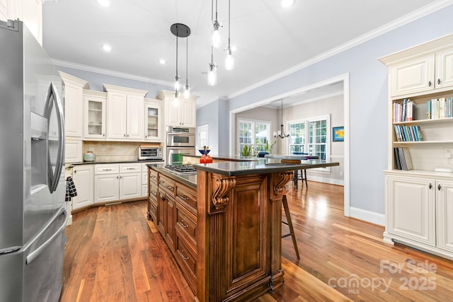 200 Galey Rdg, Cramerton, NC 28032 - kitchen with stainless steel appliances, dark countertops, a breakfast bar, wood finished floors, and crown molding