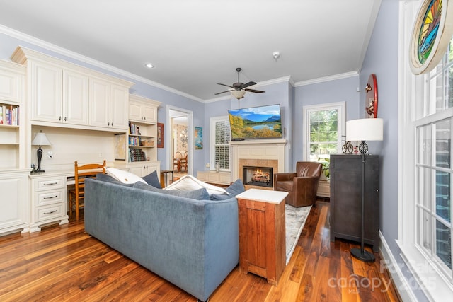 200 Galey Rdg, Cramerton, NC 28032 - living area with dark wood-type flooring, a warm lit fireplace, built in study area, crown molding, and a ceiling fan