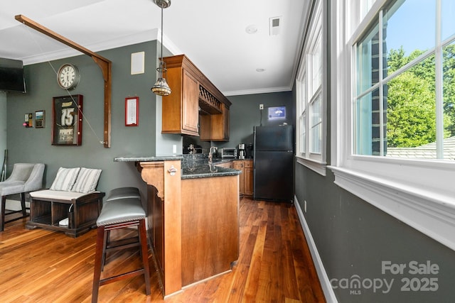 200 Galey Rdg, Cramerton, NC 28032 - kitchen with freestanding refrigerator, crown molding, brown cabinetry, dark wood-style floors, and a peninsula