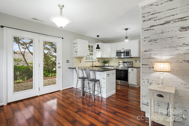 181 Farington Cir, Fletcher, NC 28732 - kitchen with appliances with stainless steel finishes, a peninsula, dark countertops, backsplash, and white cabinets