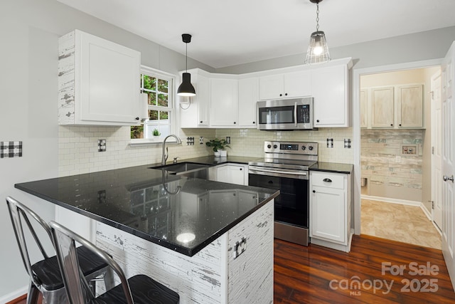 181 Farington Cir, Fletcher, NC 28732 - kitchen with appliances with stainless steel finishes, dark wood finished floors, a peninsula, and white cabinetry