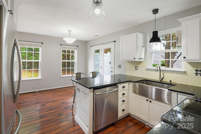 181 Farington Cir, Fletcher, NC 28732 - kitchen with stainless steel appliances, a peninsula, dark wood finished floors, decorative backsplash, and decorative light fixtures