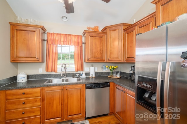 515 E Carpenter St, Maiden, NC 28650 - kitchen featuring appliances with stainless steel finishes, ceiling fan, dark countertops, brown cabinetry, and light wood-style floors