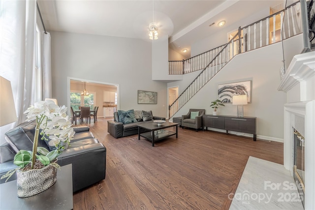 2836 Providence Spring Ln, Charlotte, NC 28270 - living room with wood finished floors, a towering ceiling, stairway, a chandelier, and a fireplace with flush hearth