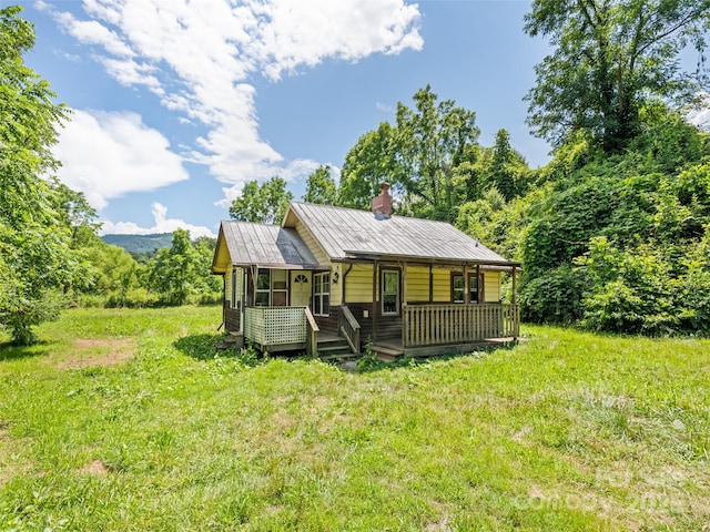 55 Shook St, Clyde, NC 28721 - rear view of property featuring a chimney, a metal roof, and a porch