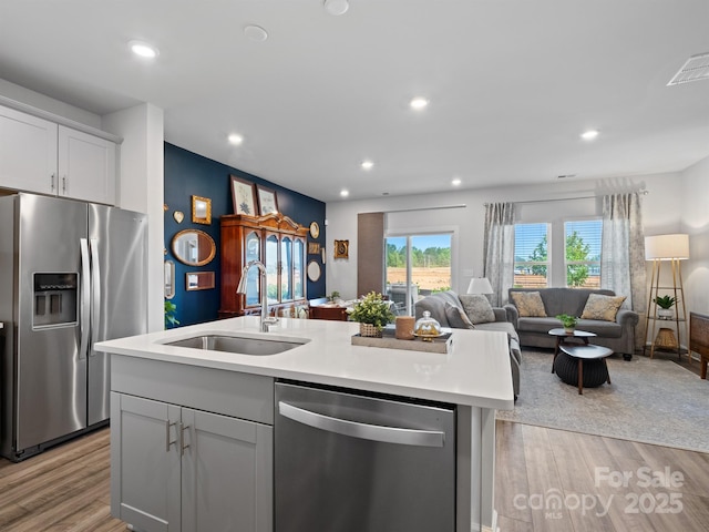 4170 County Down Ave, Kannapolis, NC 28081 - kitchen with appliances with stainless steel finishes, light wood-style flooring, open floor plan, light countertops, and a kitchen island with sink