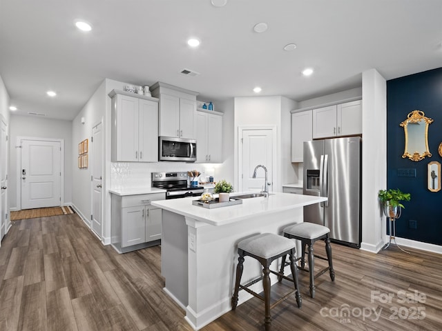 4170 County Down Ave, Kannapolis, NC 28081 - kitchen featuring appliances with stainless steel finishes, dark wood finished floors, recessed lighting, light countertops, and a kitchen bar