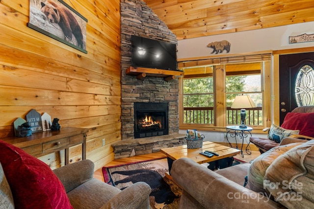55 Kirkland Mountain Ln, Bryson City, NC 28713 - living room with vaulted ceiling, wood finished floors, a stone fireplace, wooden walls, and wood ceiling