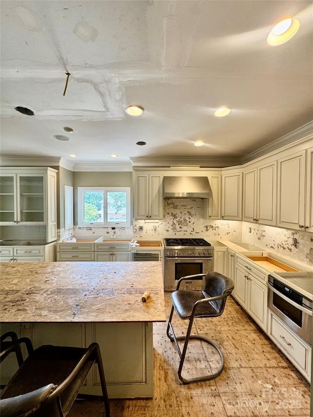 1802 Walden Pond Ln, Waxhaw, NC 28173 - kitchen with ventilation hood, high end range, cream cabinets, ornamental molding, and tasteful backsplash