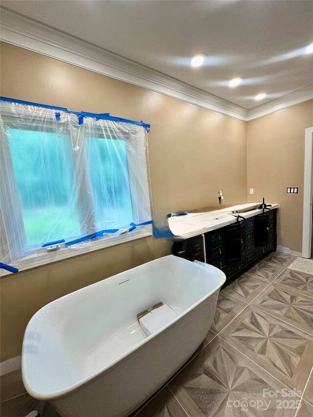 1802 Walden Pond Ln, Waxhaw, NC 28173 - bathroom with ornamental molding, a freestanding tub, and double vanity