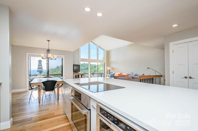 153 Country Ridge Rd, Laurel Park, NC 28739 - kitchen featuring oven, black electric cooktop, a chandelier, light wood-style floors, and light countertops