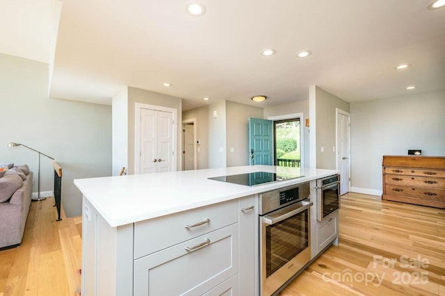 153 Country Ridge Rd, Laurel Park, NC 28739 - kitchen featuring stainless steel oven, black electric stovetop, light wood-style flooring, recessed lighting, and light countertops