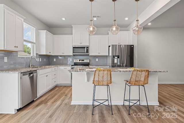 15626 Little Bluestem St, Charlotte, NC 28278 - kitchen with stainless steel appliances, a kitchen island, backsplash, a kitchen bar, and recessed lighting