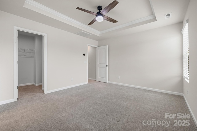 15626 Little Bluestem St, Charlotte, NC 28278 - unfurnished bedroom with a raised ceiling, ornamental molding, a spacious closet, carpet flooring, and a ceiling fan