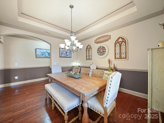 109 Dewfield Ln, Boiling Springs, SC 29316 - dining area featuring a tray ceiling, crown molding, a chandelier, arched walkways, and dark wood-style floors