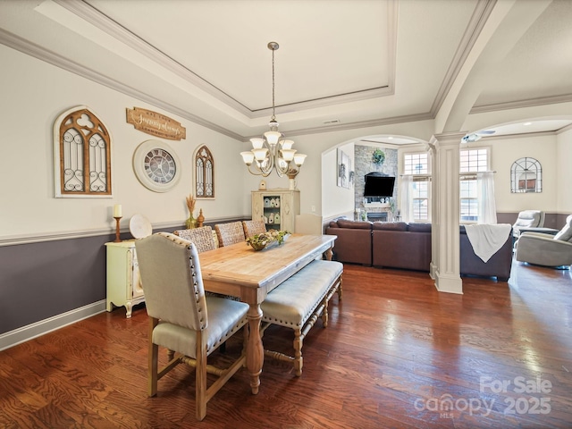 109 Dewfield Ln, Boiling Springs, SC 29316 - dining room with decorative columns, arched walkways, a tray ceiling, crown molding, and dark wood-type flooring