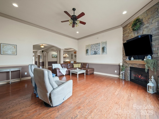 109 Dewfield Ln, Boiling Springs, SC 29316 - living area featuring arched walkways, crown molding, a stone fireplace, a ceiling fan, and wood finished floors