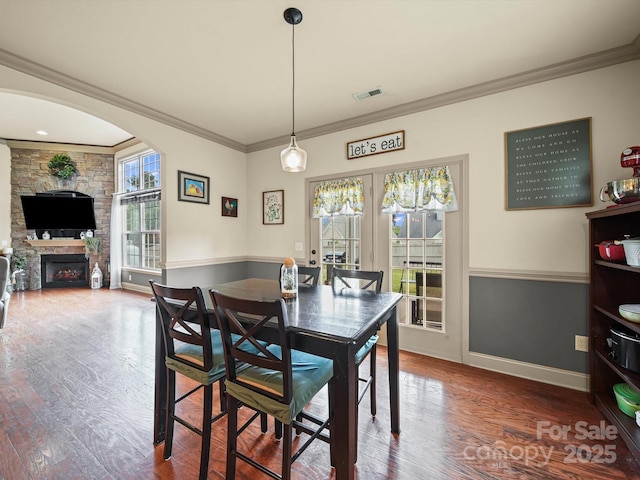 109 Dewfield Ln, Boiling Springs, SC 29316 - dining room featuring wood finished floors, ornamental molding, french doors, a stone fireplace, and arched walkways