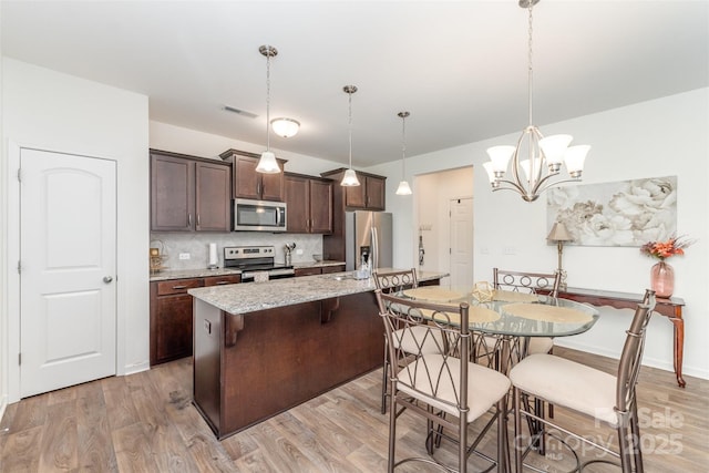 1111 Freeman View Dr, Albemarle, NC 28001 - kitchen with stainless steel appliances, dark brown cabinetry, light wood-style flooring, and backsplash