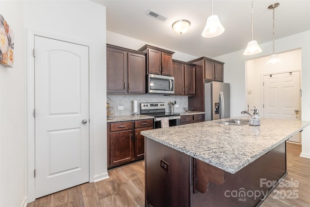 1111 Freeman View Dr, Albemarle, NC 28001 - kitchen with stainless steel appliances, light wood-style flooring, an island with sink, and dark brown cabinets