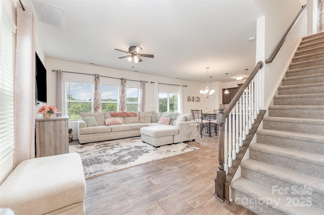 1111 Freeman View Dr, Albemarle, NC 28001 - living room featuring stairs, wood finished floors, ceiling fan, and a chandelier