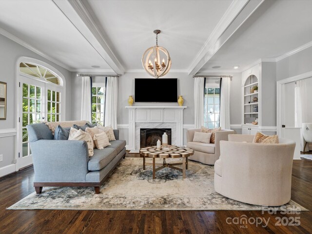 11624 Glenn Abbey Way, Charlotte, NC 28277 - living room with crown molding, built in features, a chandelier, wood finished floors, and a fireplace