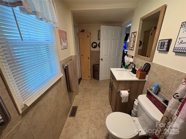 43 Mandalay Pl SW, Concord, NC 28027 - bathroom featuring tile walls, vanity, healthy amount of natural light, wainscoting, and tile patterned floors