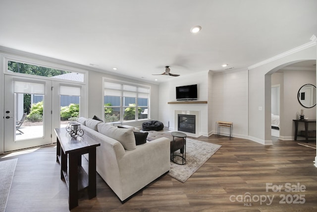 2019 Trailwood Dr, Matthews, NC 28104 - living area featuring a ceiling fan, crown molding, arched walkways, a glass covered fireplace, and recessed lighting