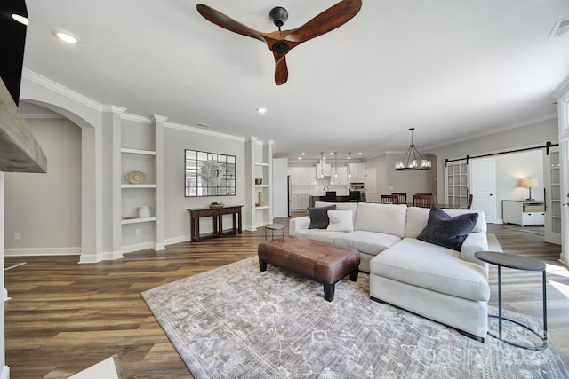 2019 Trailwood Dr, Matthews, NC 28104 - living room with built in features, a barn door, wood finished floors, a ceiling fan, and arched walkways