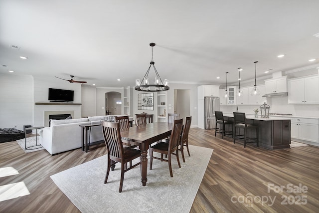 2019 Trailwood Dr, Matthews, NC 28104 - dining area with a ceiling fan, recessed lighting, dark wood-style flooring, a fireplace, and crown molding