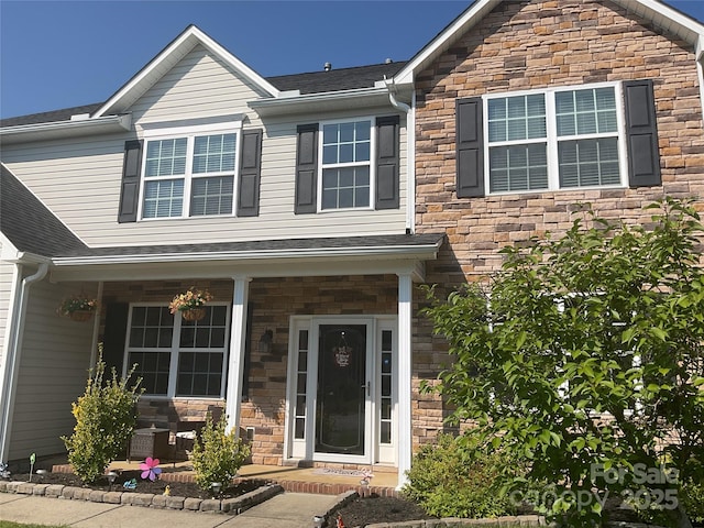 172 Roanoke Rd, Fletcher, NC 28732 - view of front of home with stone siding, covered porch, and roof with shingles