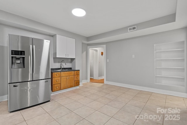 524 Bonview Ave, Lincolnton, NC 28092 - kitchen featuring stainless steel refrigerator with ice dispenser, dark countertops, white cabinets, light tile patterned floors, and built in features