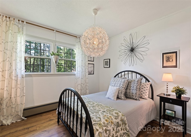 975 Buchanan Loop, Sylva, NC 28779 - bedroom with hardwood / wood-style floors, baseboard heating, and a chandelier
