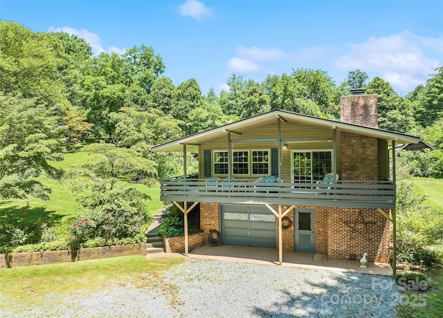 975 Buchanan Loop, Sylva, NC 28779 - view of front of house featuring a chimney, brick siding, driveway, an attached garage, and a front lawn